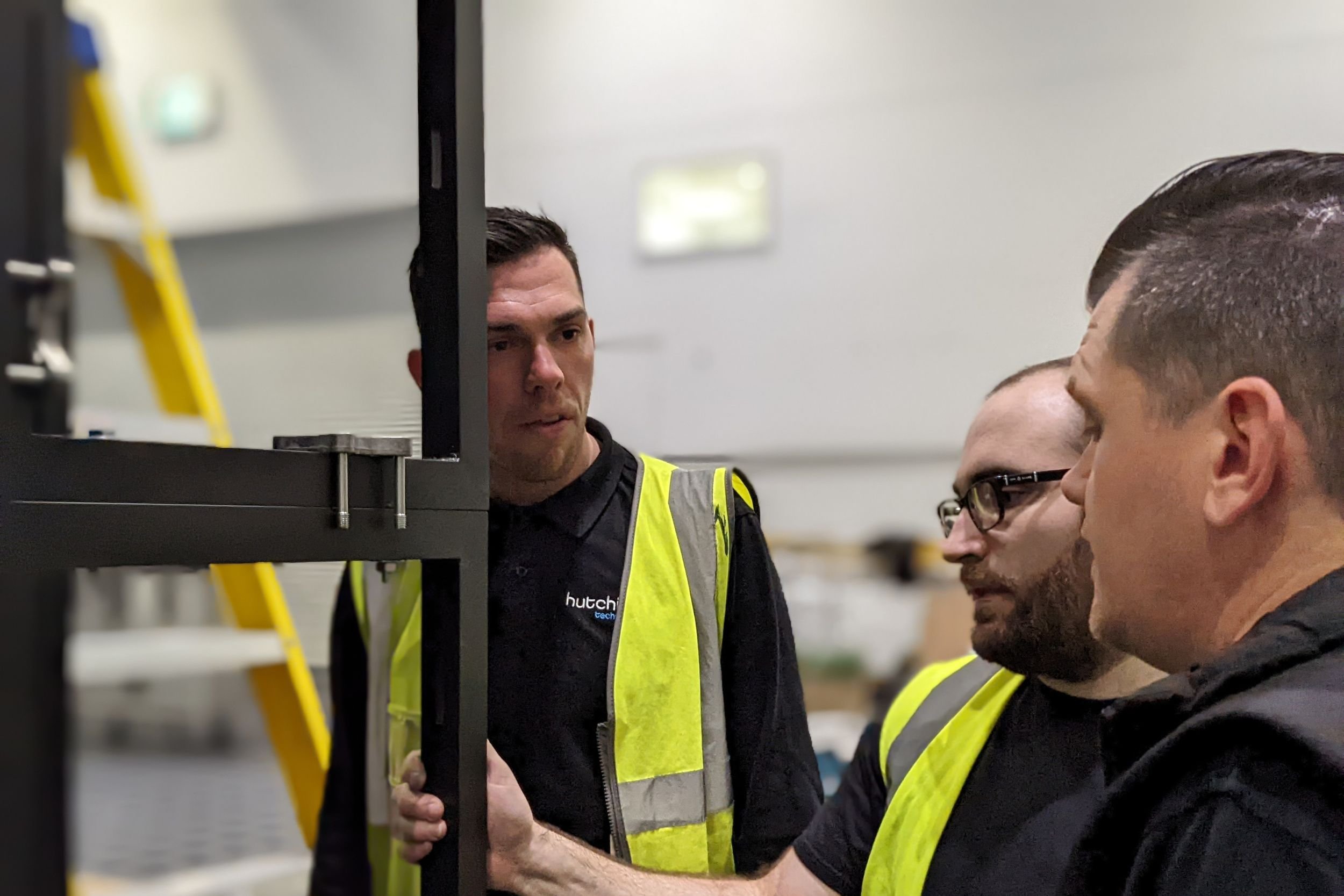 Three AV engineers standing at an AV installation